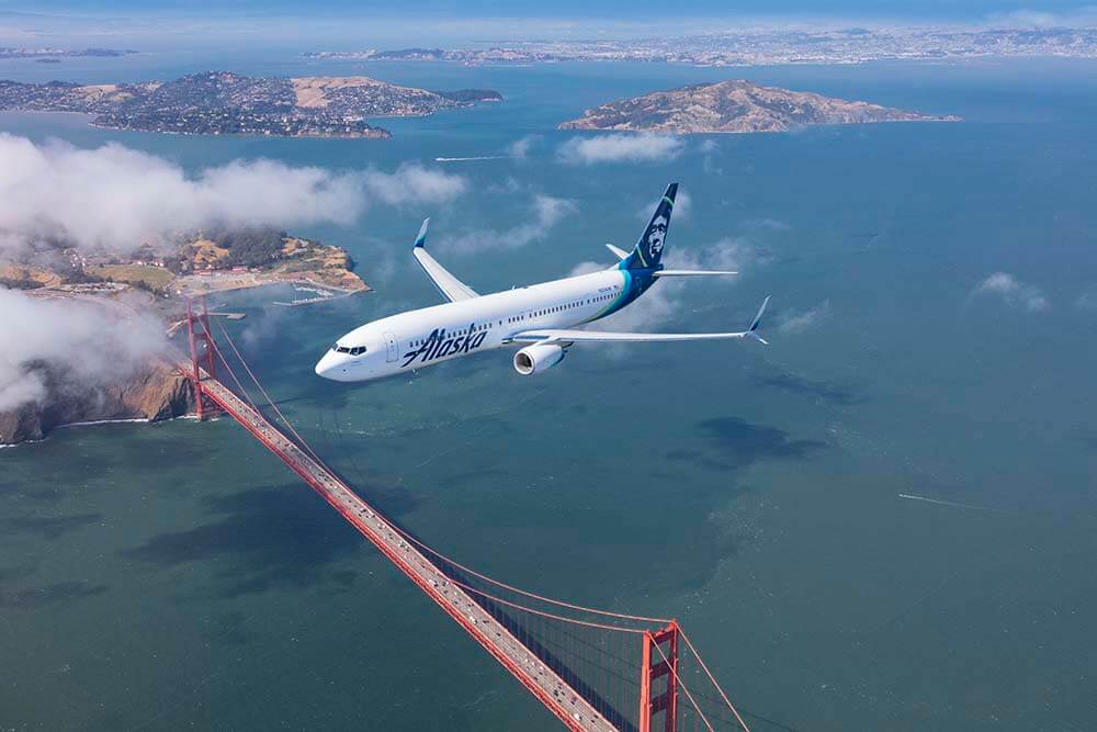 An Alaska Airlines aircraft flies over the Golden Gate suspension bridge in San Francisco