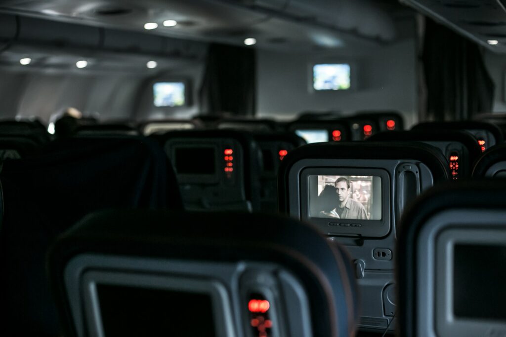 dimmed airplane cabin interior with lit up seatback displays
