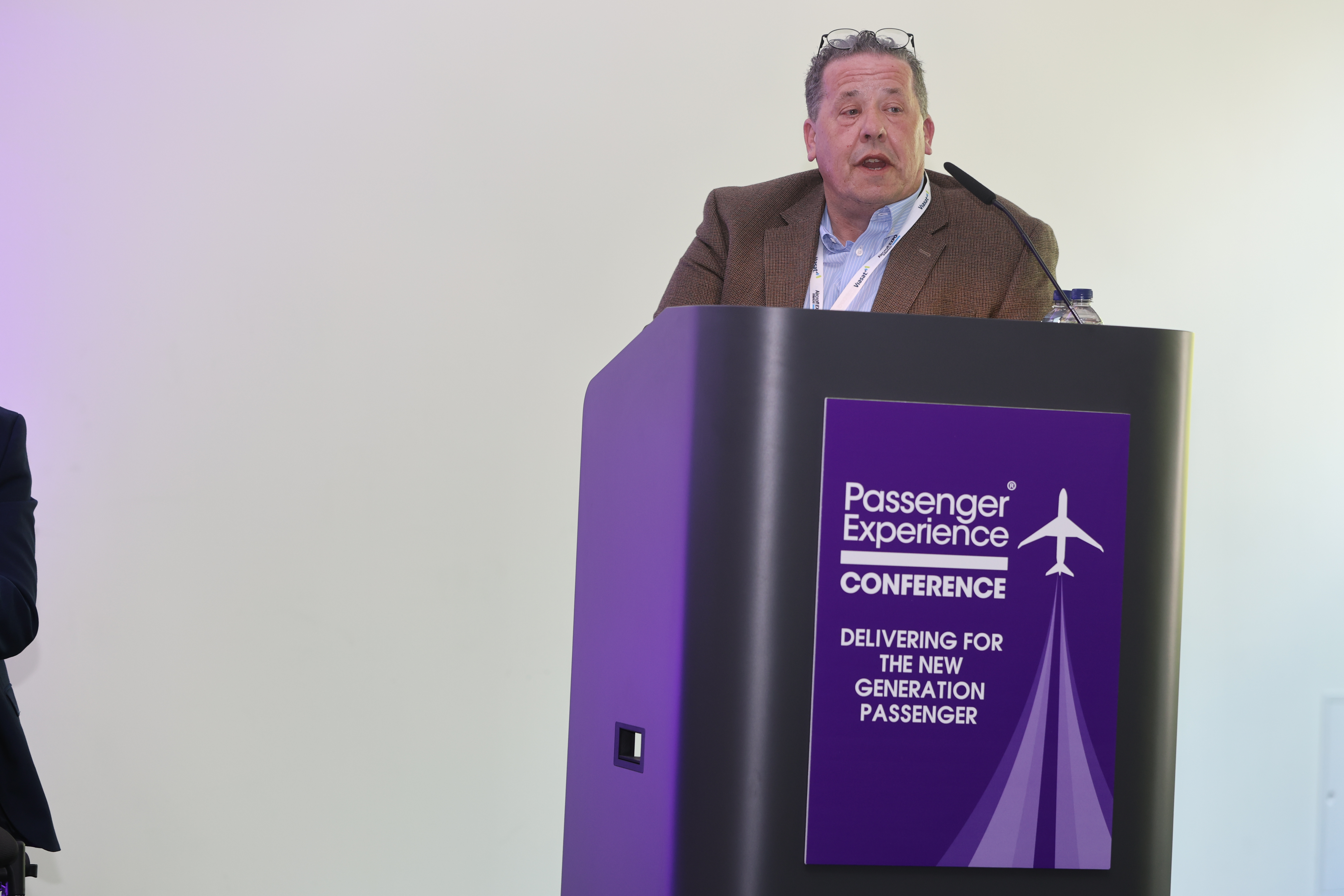 chris wood speaking at passenger experience conference 2023 from a podium
