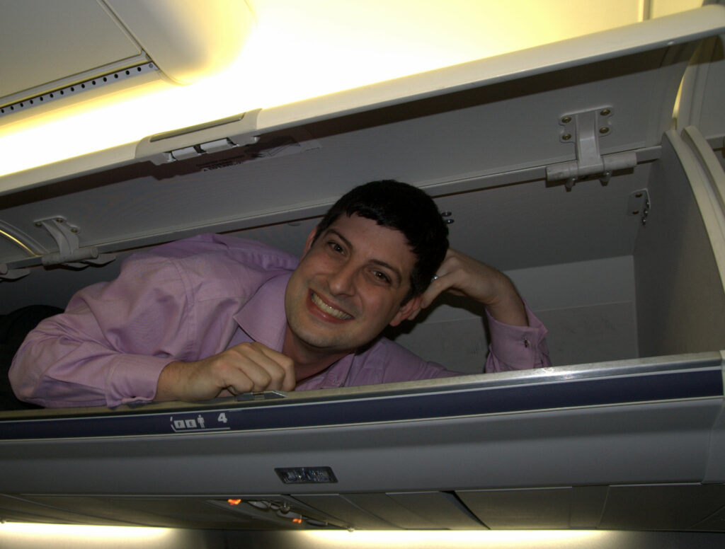 Seth Miller Founder Editor in Chief PaxEx Aero in an airplane overhead bin